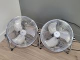 two fans that are sitting on the floor next to each other
