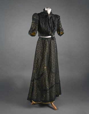 une robe noire et dorée sur un mannequin, un mannequin, un mannequin, un mannequin, un mannequin, un mannequin, un mannequin, un mannequin, un mannequin, un mannequin, un mannequin, un mannequin, un mannequin, un mannequin, un mannequin, un mannequin, un mannequin, un mannequin, un mannequin, un mannequin, un mannequin, un mannequin, un mannequin, un mannequin, un mannequin, un mannequin, un mannequin, un mannequin, un mannequin, un mannequin, un mannequin, un mannequin, un mannequin, un