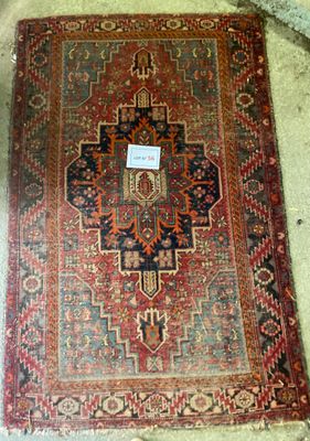 un tapis rouge et bleu posé sur un sol en béton