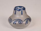 un vase bleu et blanc posé sur une surface blanche