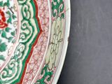 a red and green plate sitting on a black table