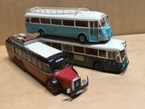 deux bus miniatures posés l'un à côté de l'autre sur une table