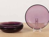 two purple plates and a purple bowl on a table