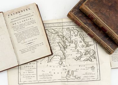 an old book sitting on top of a table next to an open book