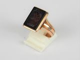 Gros plan sur une bague en or ornée d'une pierre noire