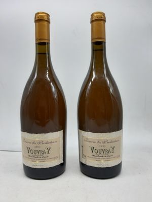 deux bouteilles de vin posées l'une à côté de l'autre sur une surface blanche
