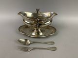 une assiette en argent sur laquelle sont posées une cuillère et une autre cuillère