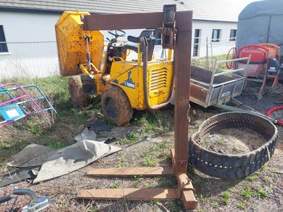 un chariot élévateur garé à côté d'un tas de ferraille