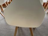 four white chairs sitting in a room with a balcony in the background