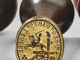 three wooden balls with a gold coin on them sitting next to each other