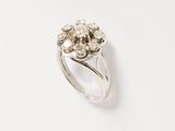 a close up of a diamond ring on a white surface