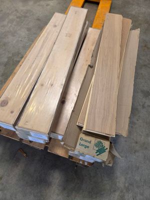 plusieurs pièces de bois sont empilées sur une palette dans un entrepôt