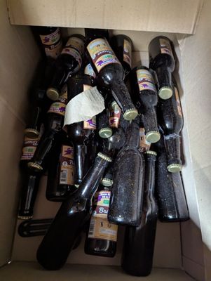 a box full of empty beer bottles sitting on the floor