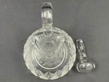 a glass bowl with a spoon and spoon rest next to it