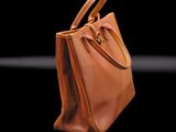 brown leather handbag on a black background