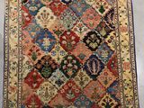 un tapis persan ancien présentant un motif multicolore sur fond blanc