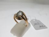 l'image d'une bague en or ornée d'une pierre verte