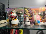 two books on a shelf next to two figurines on a shelf