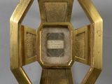 une image représentant une horloge dorée avec une illustration au centre