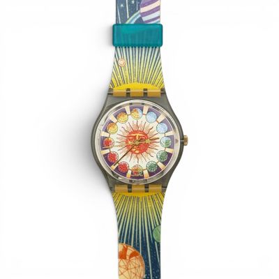 a close up of a watch on a white surface with a blue strap