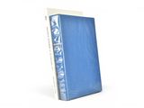 un livre bleu posé sur une surface blanche