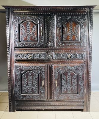 an old wooden cabinet with carvings on the doors and drawers