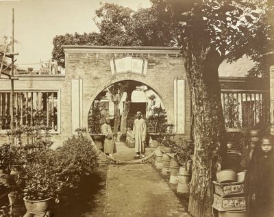 une photo en noir et blanc montrant deux personnes debout dans un jardin
