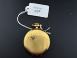 a close up of a gold pocket watch on a black surface