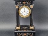 a black and gold clock sitting on a table