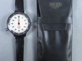 une montre posée à côté d'un sac noir