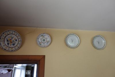 cinq assiettes accrochées au mur au-dessus d'un miroir