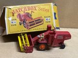 un camion jouet rouge et un tracteur rouge devant une boîte de Matchbox