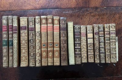 several old books are lined up in a row on a table