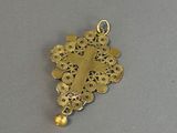 a close up of a gold pendant with a cross on it