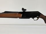 le fusil est posé sur un support transparent, sur une surface blanche