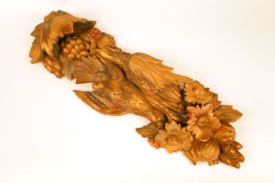 une sculpture en bois représentant un oiseau orné de fleurs