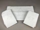 trois serviettes blanches ornées de monogrammes brodés, posées sur une table