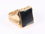 l'image d'une bague en or ornée d'une pierre noire