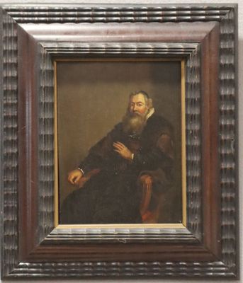 portrait d'un homme barbu assis sur une chaise près d'un mur