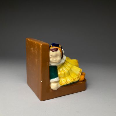 une petite figurine représentant une personne assise sur une chaise
