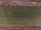 a brass plaque on a wooden table that reads the name of a man