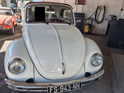 une Coccinelle VW blanche garée dans un garage