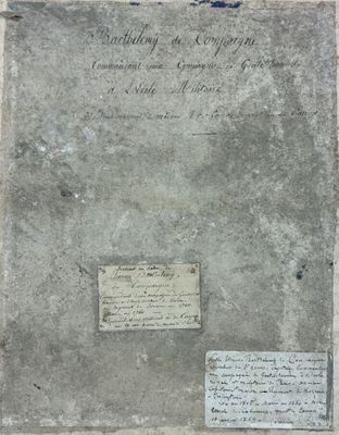 an old book sitting on top of a table next to a piece of paper