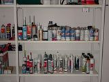 a white shelving with lots of cleaning supplies on it