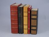 several books are lined up in a row on a white surface