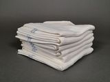 plusieurs serviettes blanches empilées les unes sur les autres sur une table