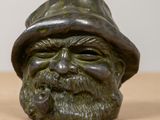 a statue of a man with a hat and a pipe in his mouth