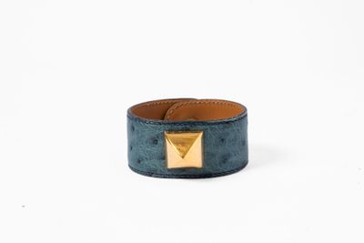 un bracelet en cuir bleu orné d'une pyramide en or