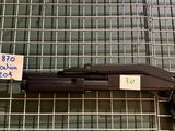 une arme exposée dans une vitrine grillagée
