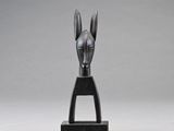une sculpture noire représentant une tête de cheval, posée sur un socle noir
